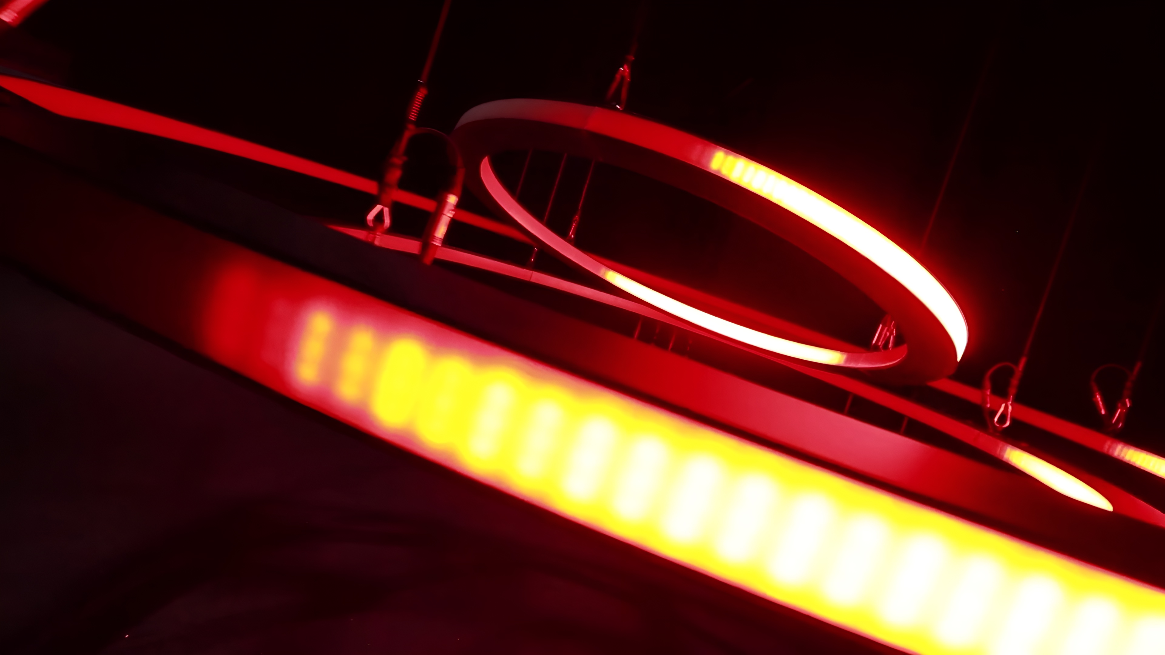 Close-up of the kinetic chandelier's rings glowing red, with individual LEDs visible along the largest ring