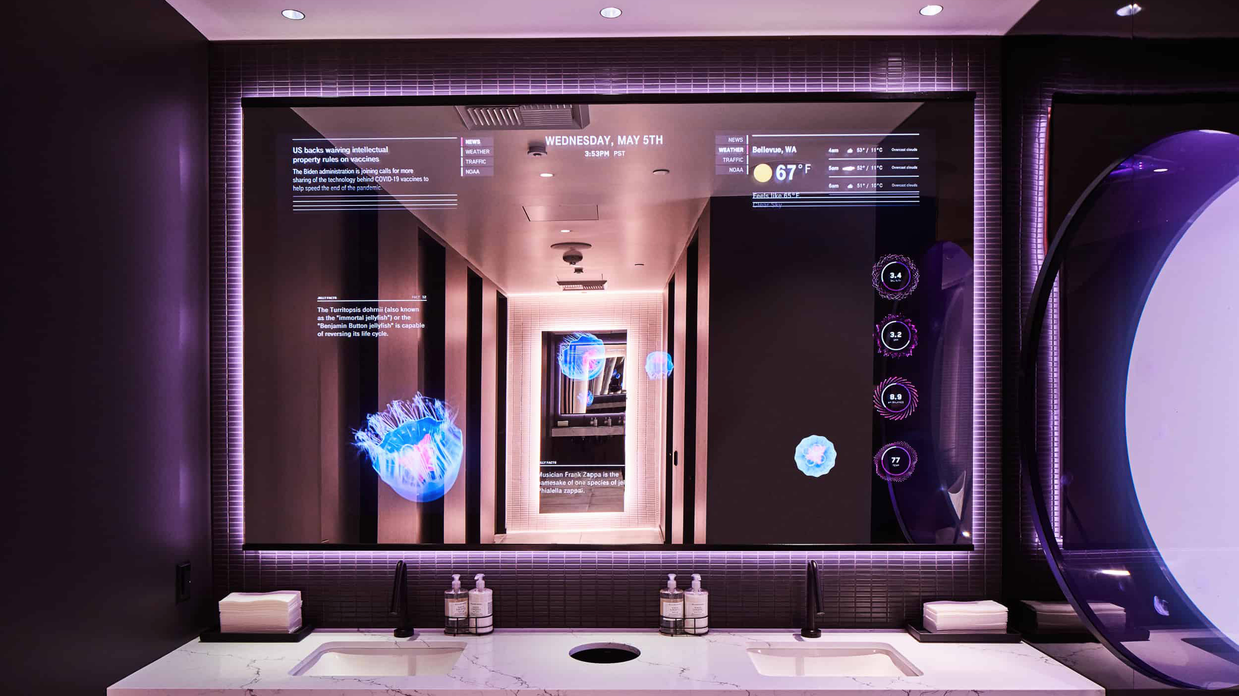 Smart mirror above twin washbasins showing the date, weather, news and glowing avatar graphics