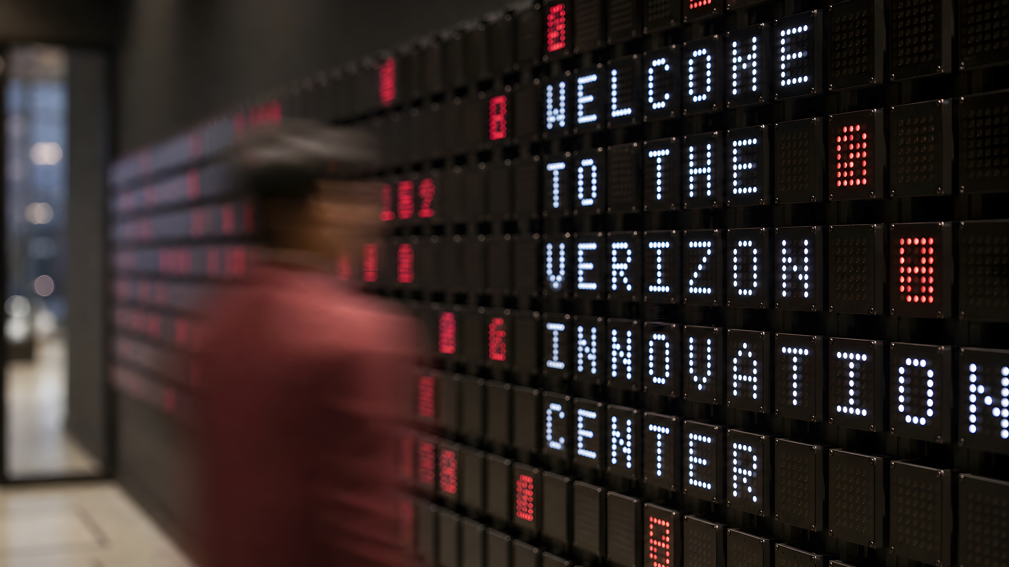 Close-up of the wall spelling Welcome to the Verizon Innovation Center as a visitor passes