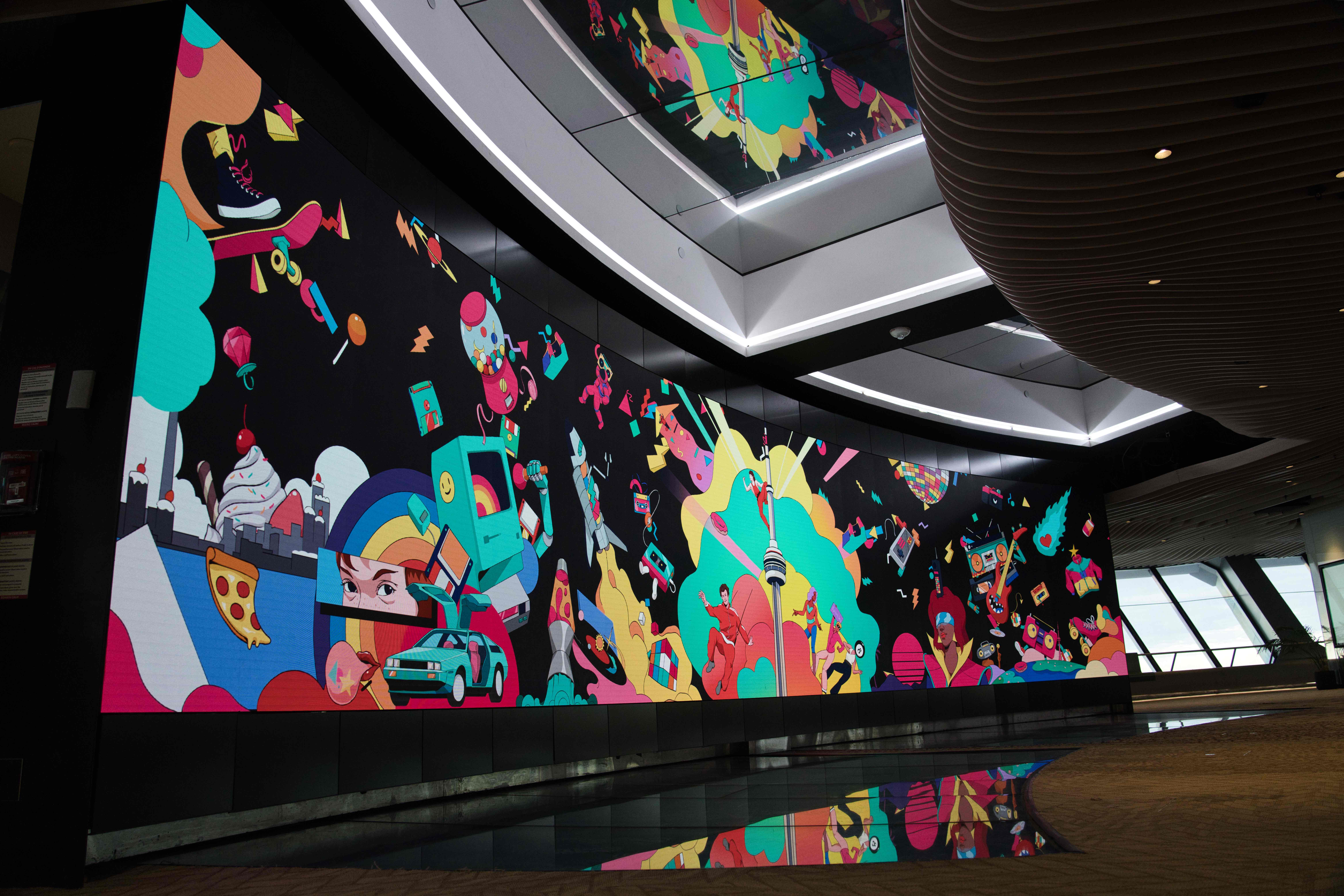 Colourful retro pop-art collage around the CN Tower on the curved video wall, mirrored in the floor and ceiling