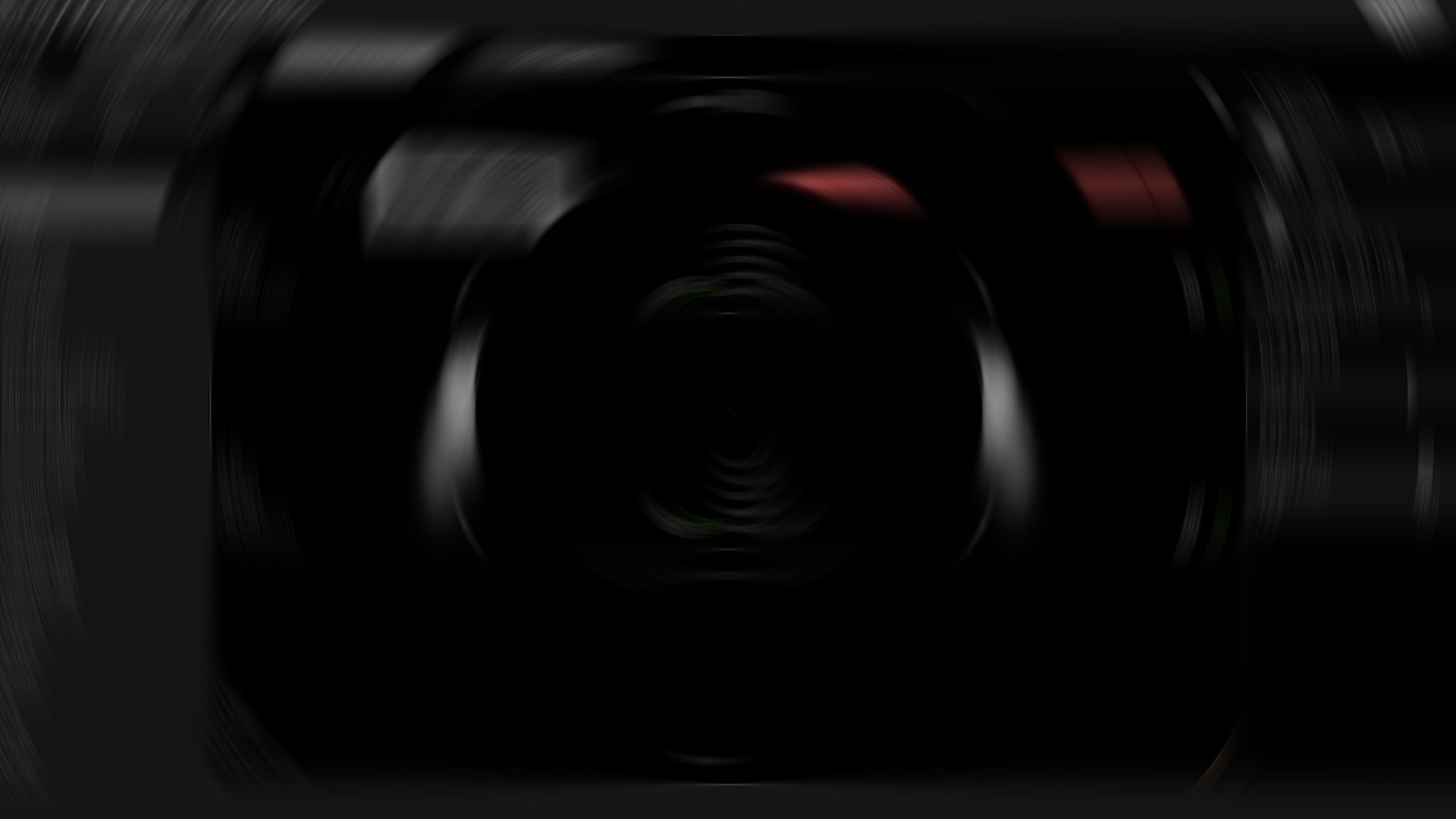 Abstract, motion-blurred dark view with faint red and white light accents
