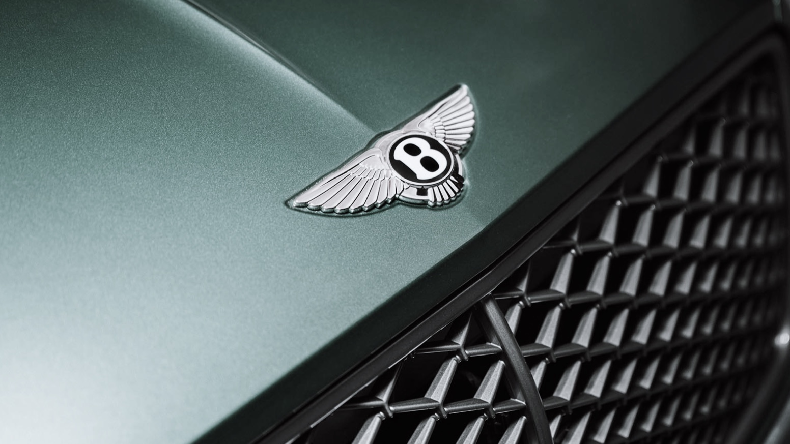 Bentley winged B badge on a dark green bonnet above the diamond-mesh grille