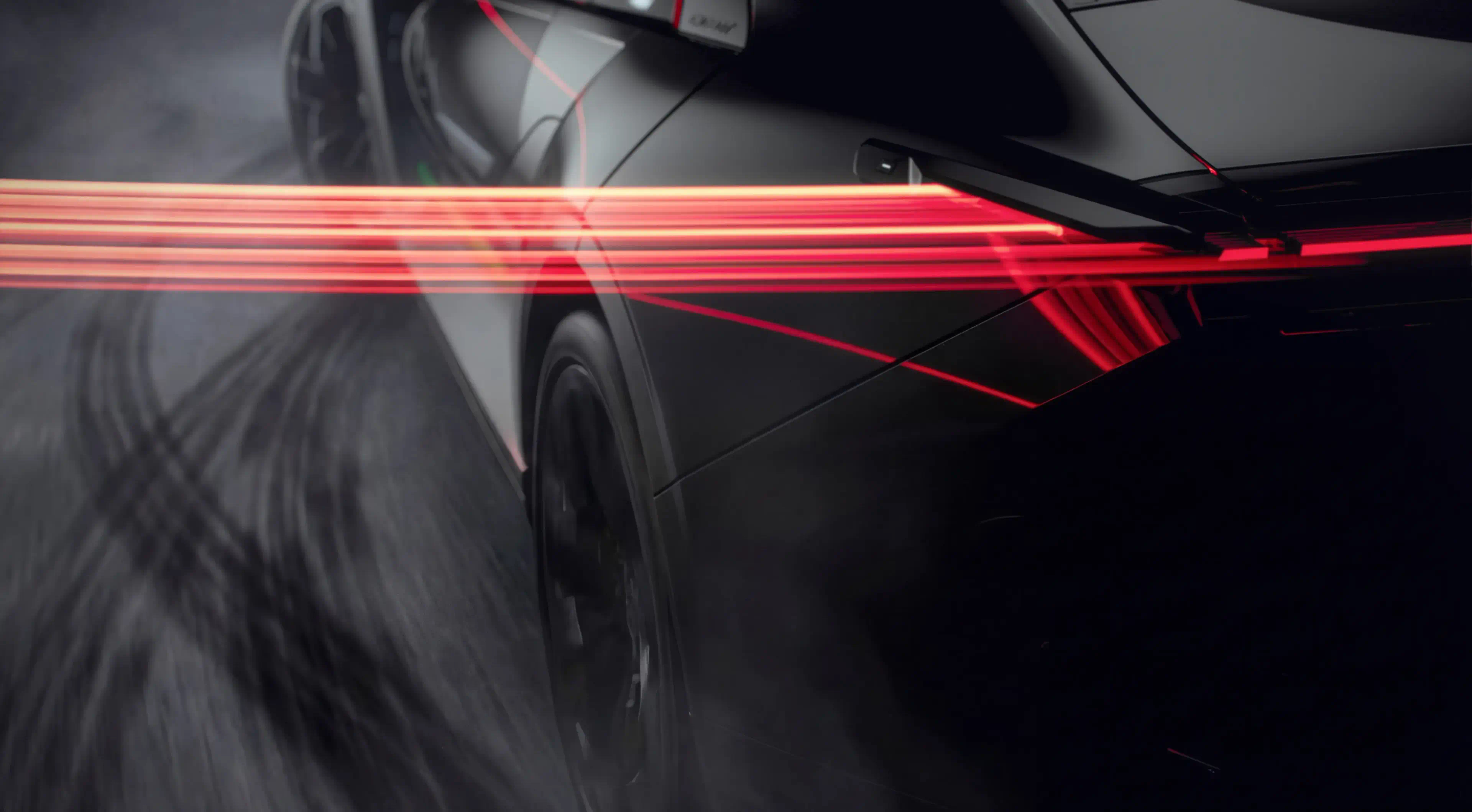 Red light trails streak back from the rear lamp of a dark CEER car in motion